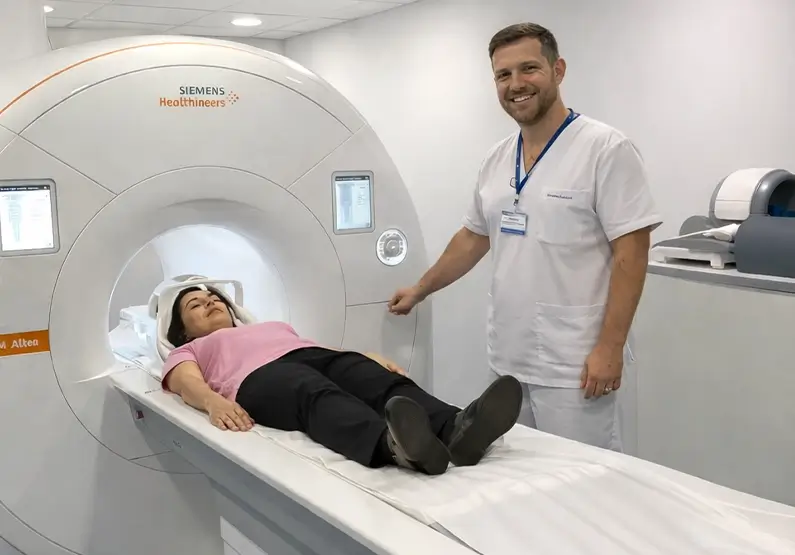 Paciente en equipo de resonancia con personal sanitario